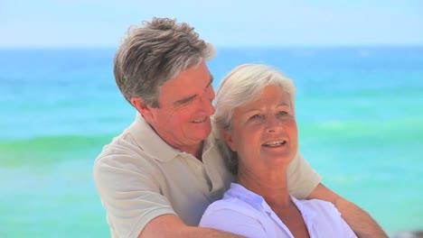 Elderly-man-giving-his-wife-a-cuddle