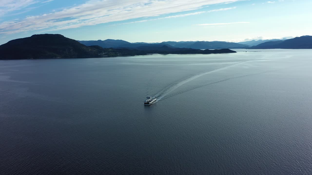 Car and passenger ferry ytteroiningen crossing open sea underway between Sydnes and Utbjoa - Electric zero emission ferry distant aerial overview - Noway