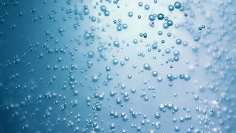 Many-water-bubbles-in-blue-water-close-up,-abstract-water-wave-with-bubbles-in-slow-motion.