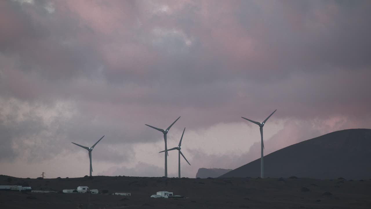 다채로운 저녁 하늘을 향해 회전하는 언덕의 풍차
