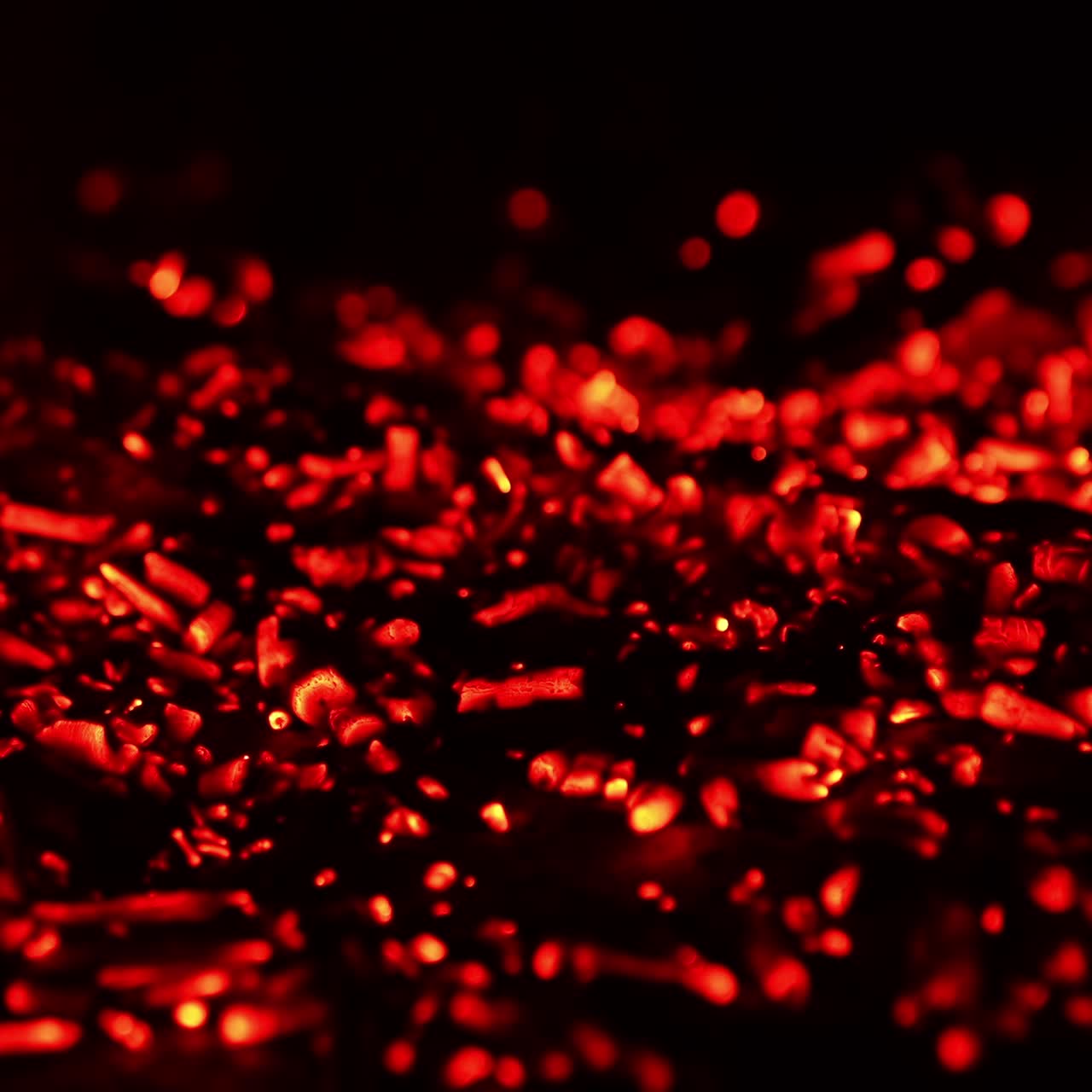 Pile of glowing charcoal after the campfire burnt out. Red pieces of burned wood still hot. Close up