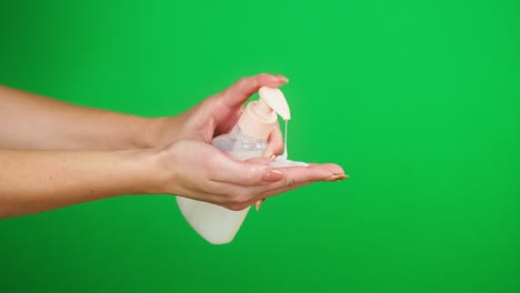 lavar las manos de las mujeres en fondo verde, empujar el dispensador y usar jabón líquido o espuma. prevención de virus, protección de seguridad. brazos con desinfectante antibacteriano de espuma de primer plano