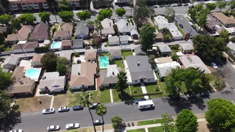 FedEx-delivery-van,-delivering-package-to-home-in-Sherman-Oaks,-Van-Nuys-house,-aerial-view