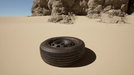 a discarded tire lies in the sand of a desert