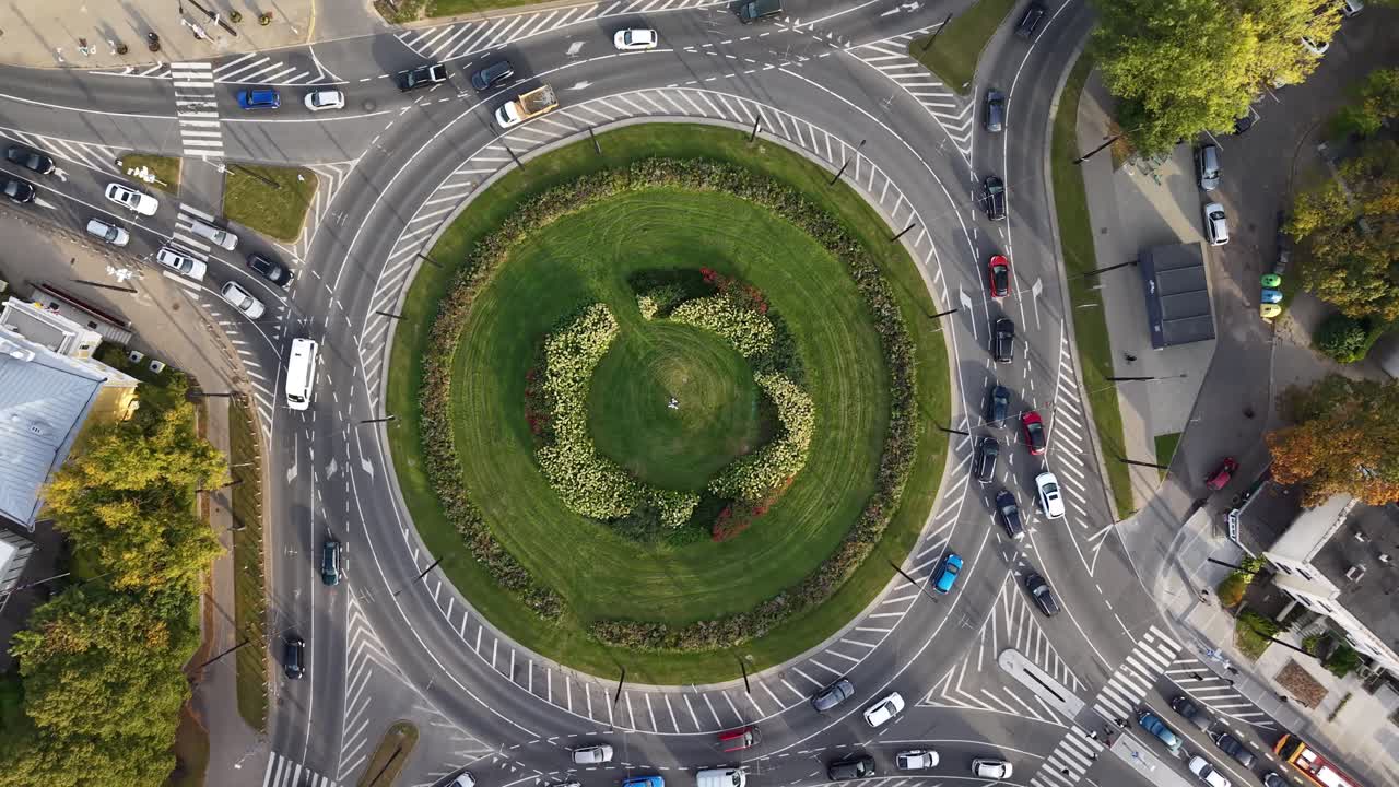 Top-down drone shot slowly rotating above a busy roundabout during evening traffic