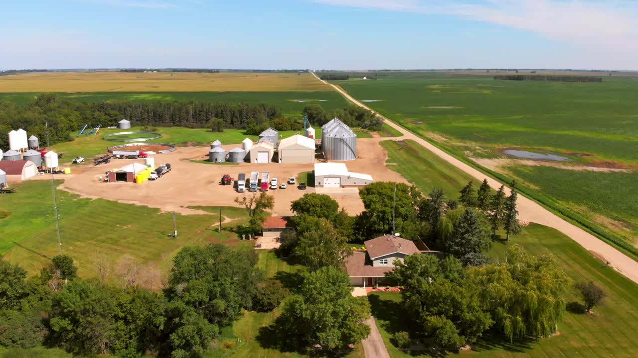 Aerial boom-down revealing North Dakota farmhouse, family home, silos, and surrounding soybean fields