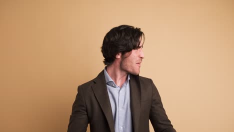 successful businessman clenching fists in brown studio