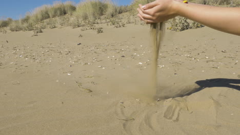 Sand-Fällt-Durch-Die-Hand-Einer-Frau