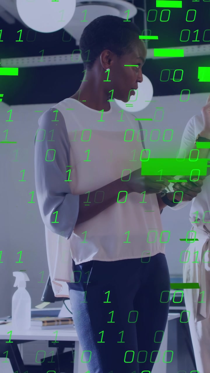 Vertical video: Phone lighting woman in blouse showing screen to peer at office with green binary