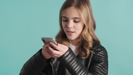 teenage caucasian girl recording voice message on her smartphone.