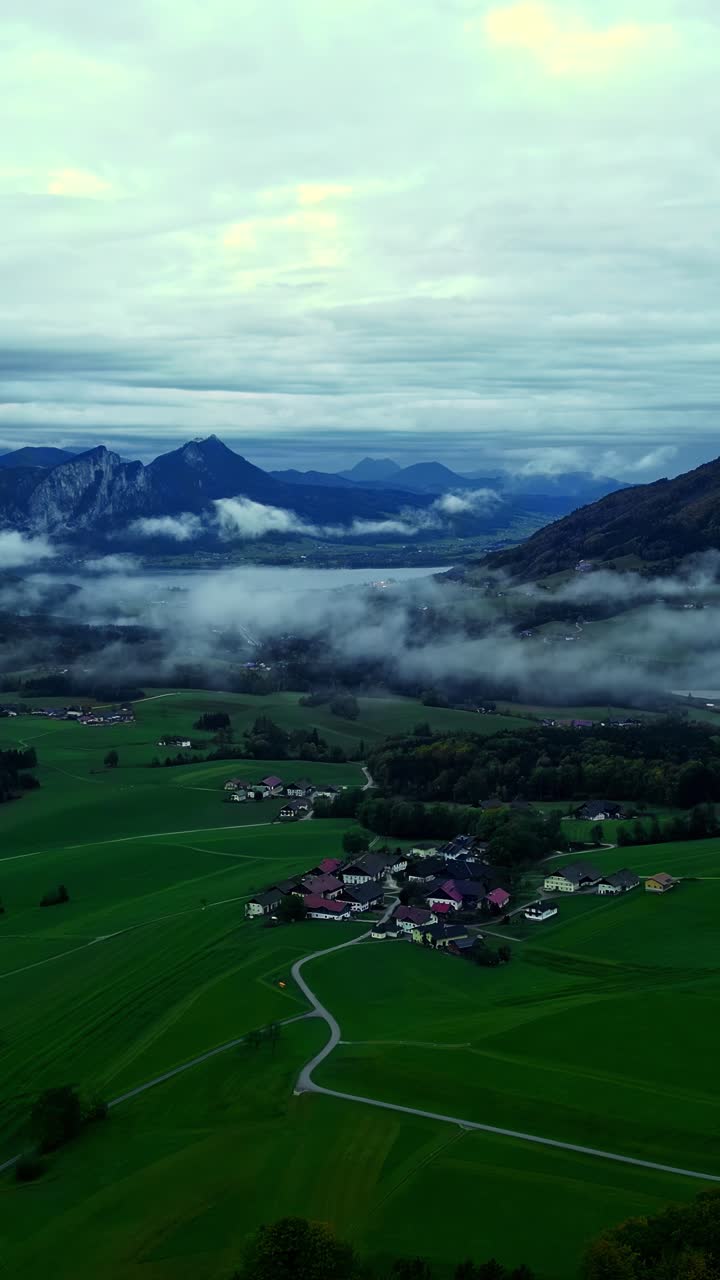 Aerial view of misty mountains and village in morning light, tranquil scene
