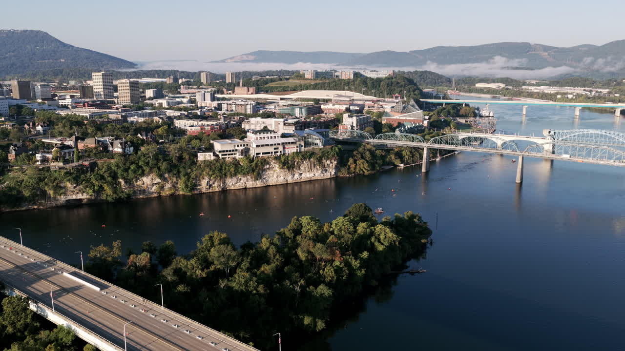 A sweeping view of Chattanooga captures the Ironman swim course winding below the Walnut Street Bridge with the city skyline beyond
