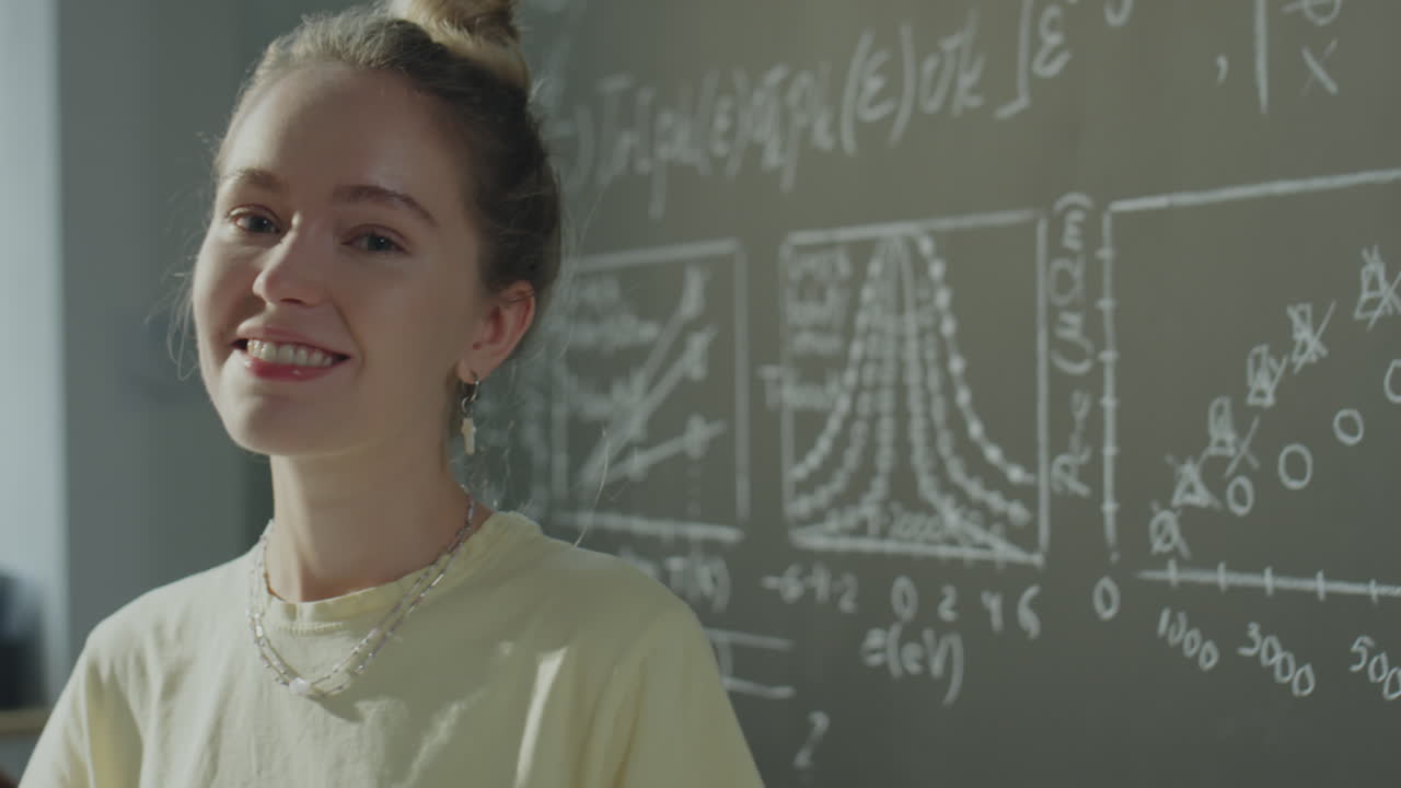 Smiling Young Woman in Front of a Chalkboard with Scientific Formulas