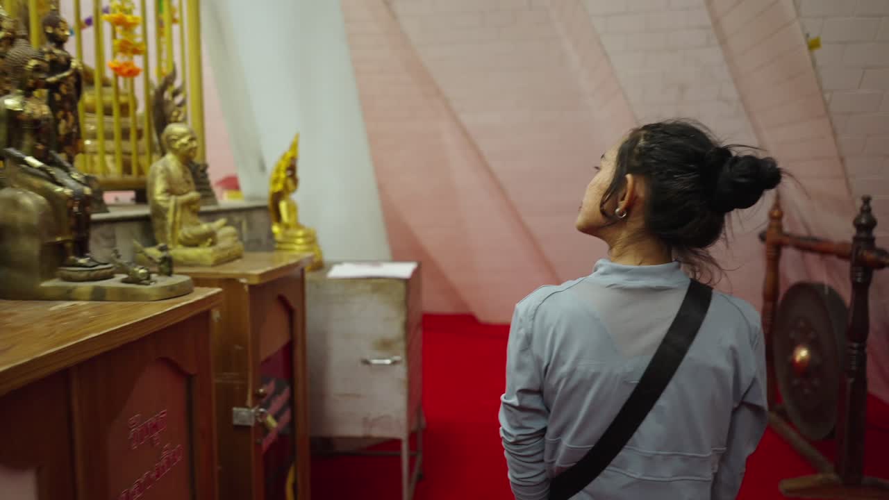 Woman admiring Buddha statues in a Buddhist temple