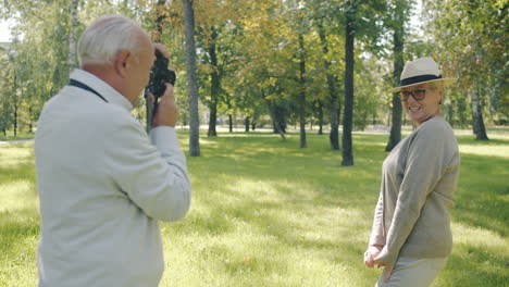 senior couple in park taking pictures