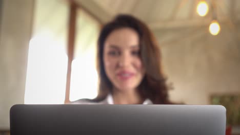 mujer feliz ejecutiva sonriendo mientras trabaja desde casa usando su computadora portátil