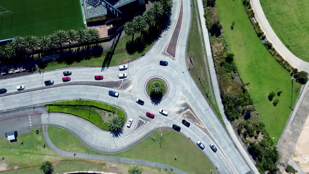 Drone aerial landscape of cars and transport moving through urban roundabout with trees park and waterfront in Gosford city CBD Central Coast Australia travel infrastructure and transport scenery
