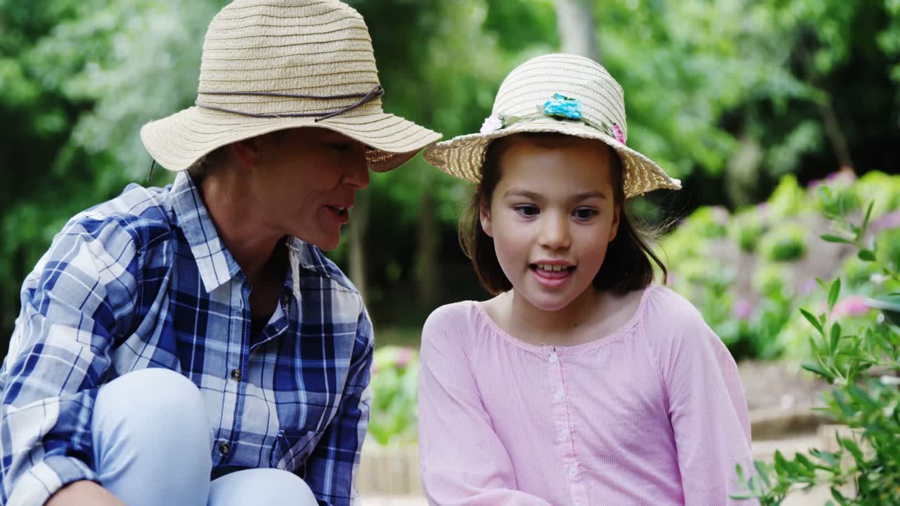 어머니 와 딸 이 정원 을 가꾸고 있다
