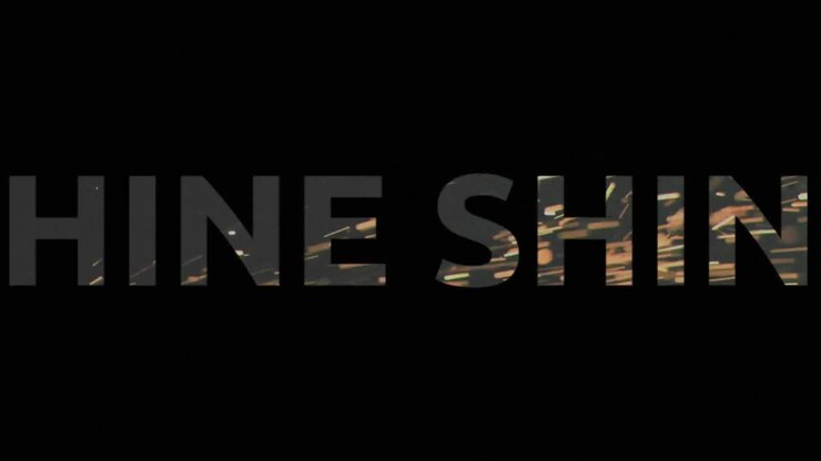 Animation of shine in white text with pink crosses and green lines over glowing sparks on black