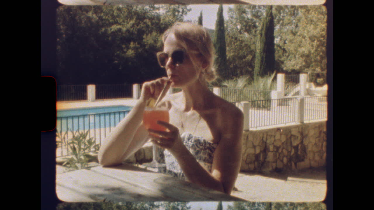 Woman relaxing with cocktail by poolside in retro summer setting