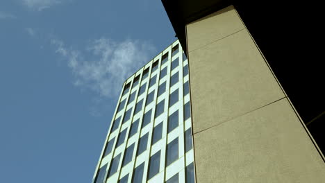 composición urbana abstracta: la fachada de vidrio reflectante del rascacielos contra un cielo azul claro