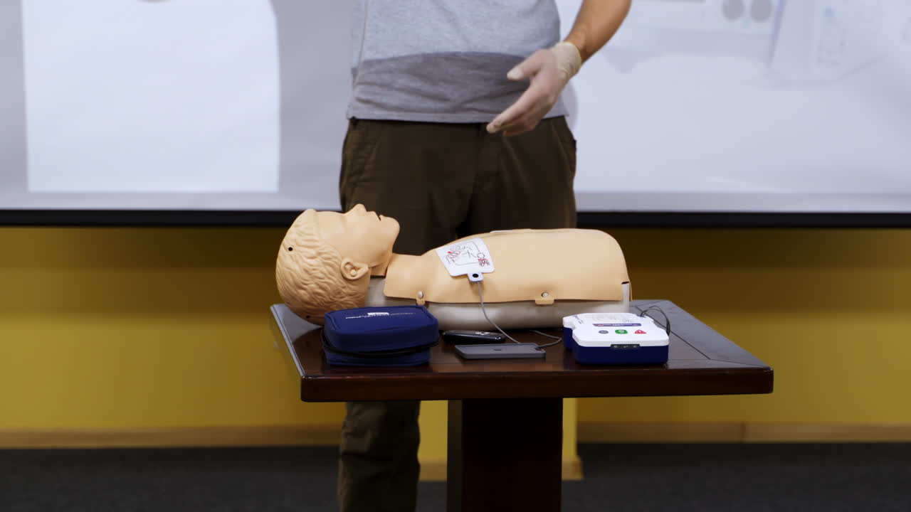 Emergency first aid CPR procedure. Demonstrating chest compressions on CPR doll in the class