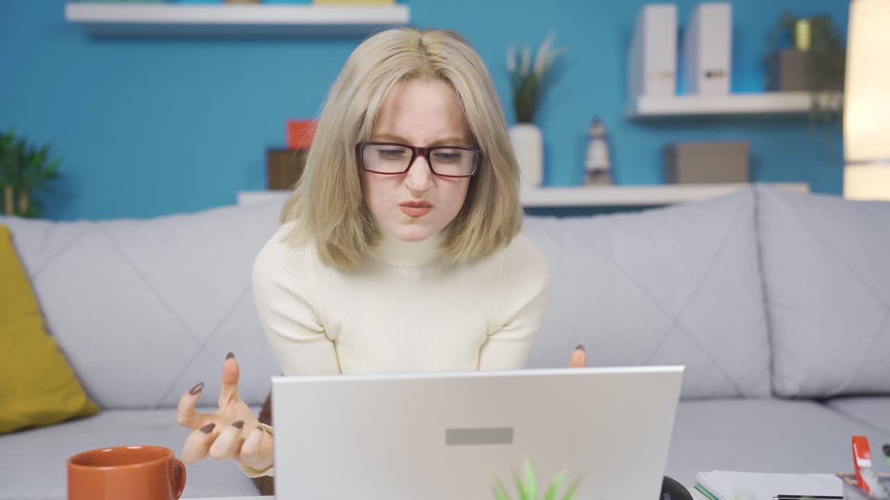Ung kvinde, der læser dårlige nyheder på laptop og ser desperat ud