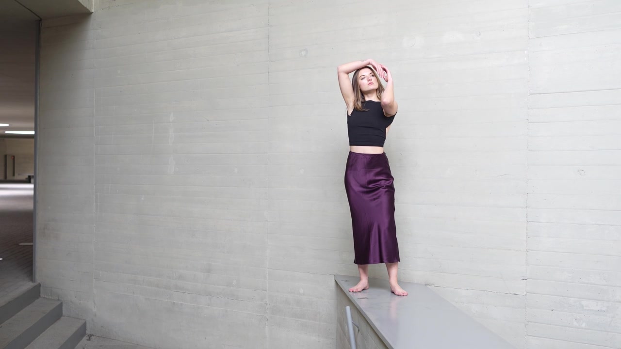 Exploring dynamic dance poses within a stunning modern architectural setting and landscape