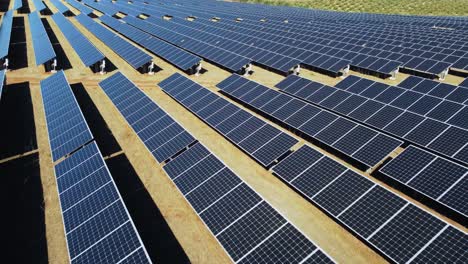 flying above solar park, big array of solar panels