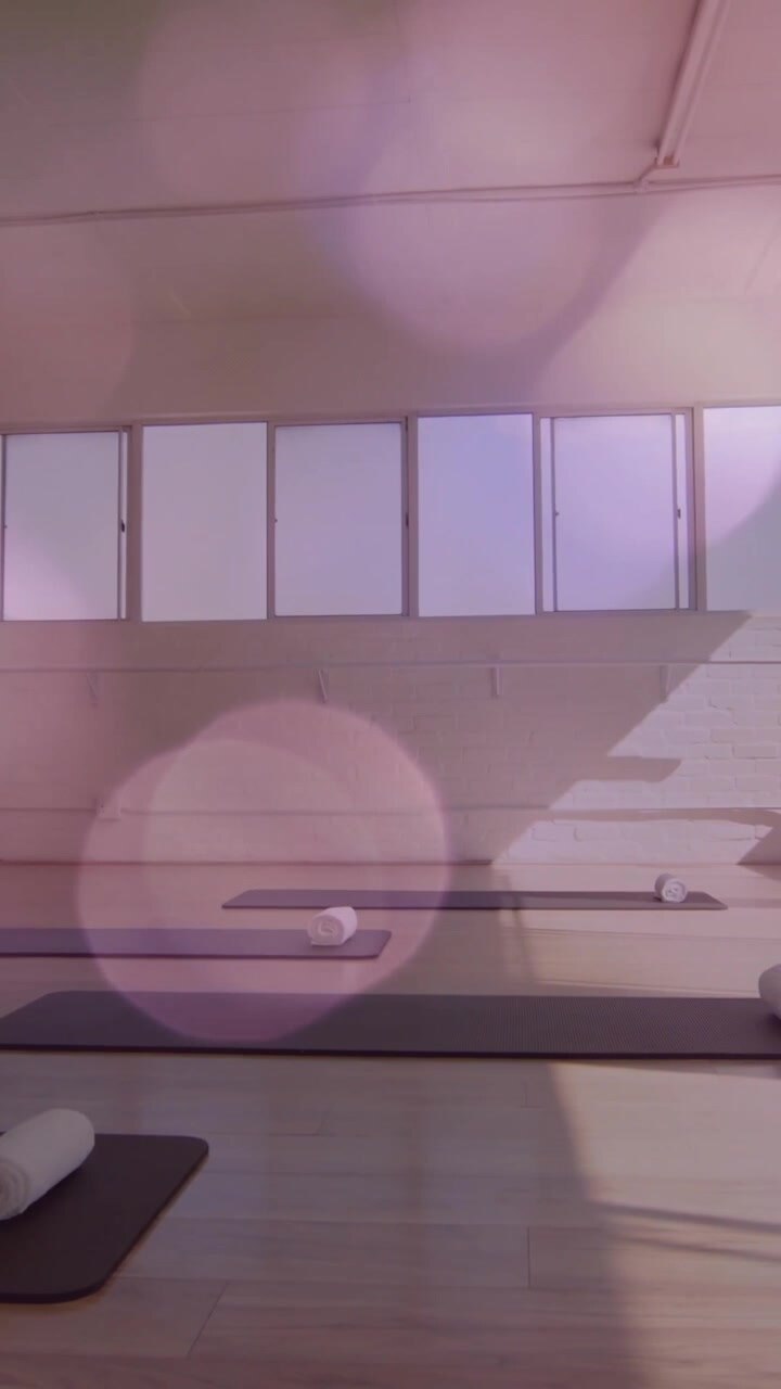 Tappetini da yoga e asciugamani in uno studio vuoto con animazione di luci bokeh.