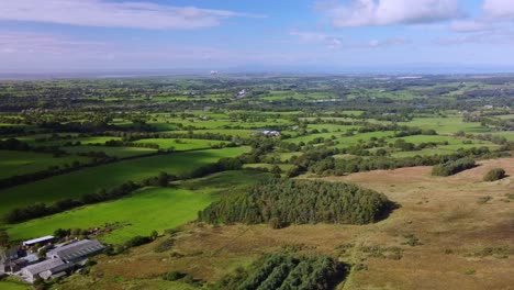 Drone-View-Of-Sunny-Autumn-Evening-English-Country-Scene-With-Woods-In-Lancashire-Looking-Towards-Heysham-Nuclear-Power-Station