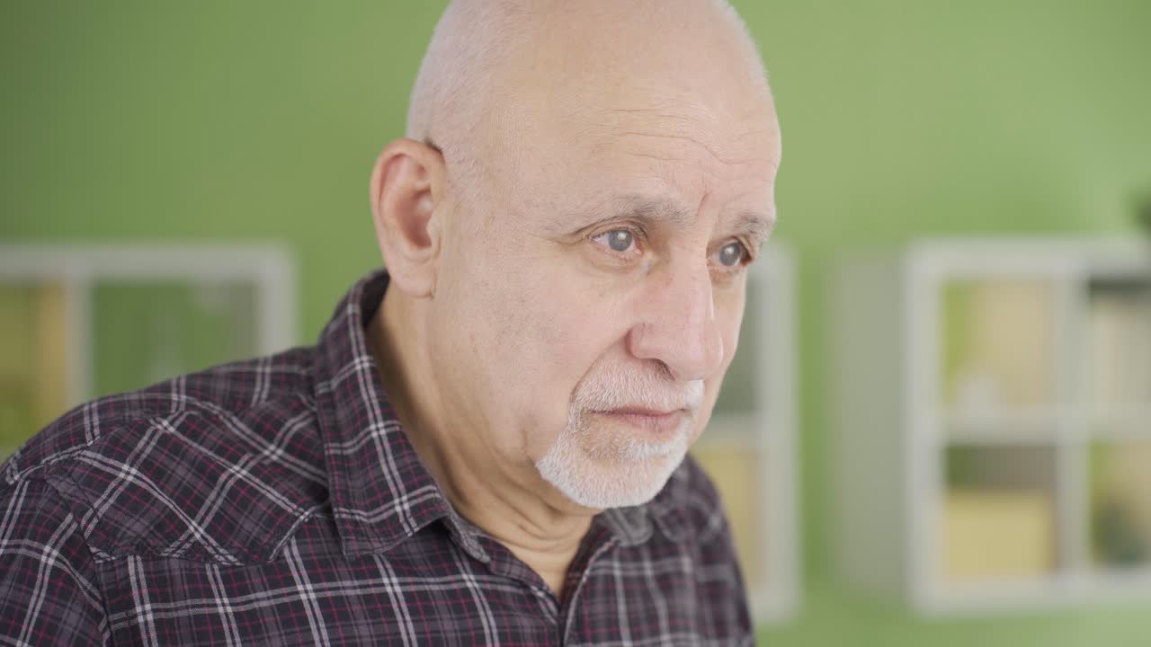 Sad old man is thoughtful at home unhappy. Blue eyed man.