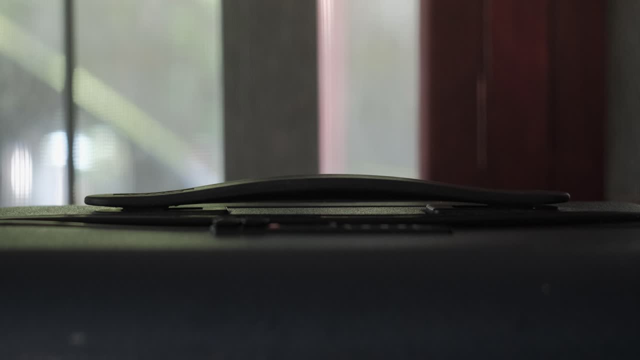 Primo piano statico di una mano che afferra e solleva la maniglia superiore di una valigia da viaggio