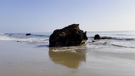 Vista-Del-Océano-Con-Olas-Rodando-En-Una-Playa-De-Arena-En-Malibu-California-Durante-Una-Tarde-Soleada