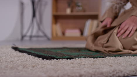 primer plano de una mujer musulmana con hijab en casa orando arrodillada en la alfombra de oración 4