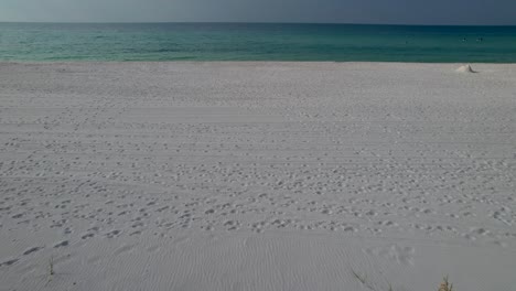 fly over on sand dunes on white sand beach in florida on a sunny day with clear waters