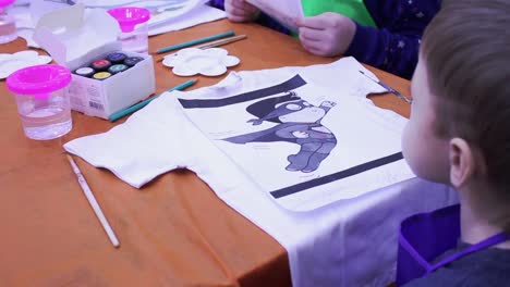 kids painting t-shirts with superheroes