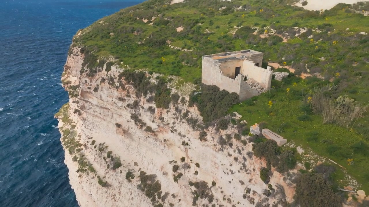 Vista aerea con drone di una storica torre di avvistamento sulla scogliera sopra la costa mediterranea