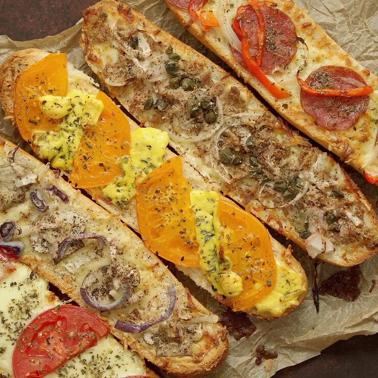 composizione di gustosi panini caldi al forno con vari condimenti formaggio tonno mozarella spezie