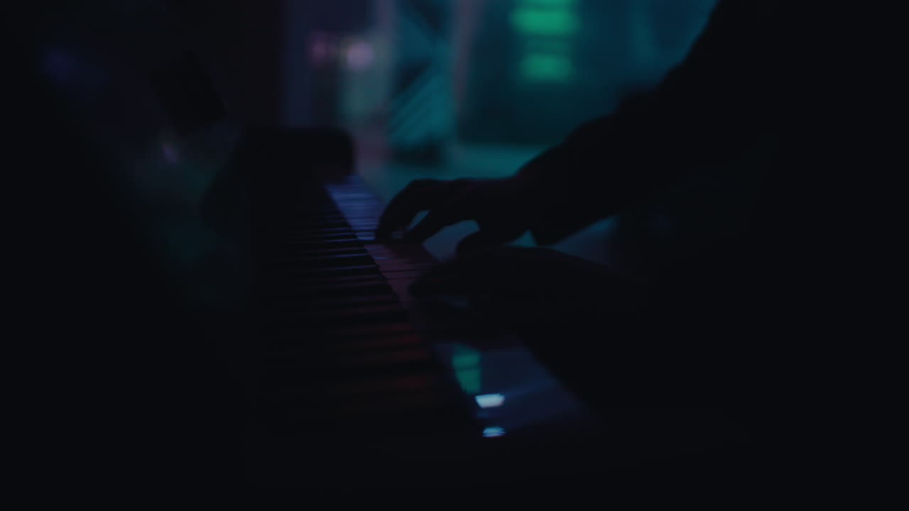 persona tocando el piano en la oscuridad
