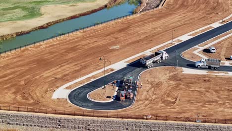 vista aérea de un equipo de pavimentación de carreteras trabajando con un pavimentador de asfalto y un camión en un nuevo sitio de carreteras