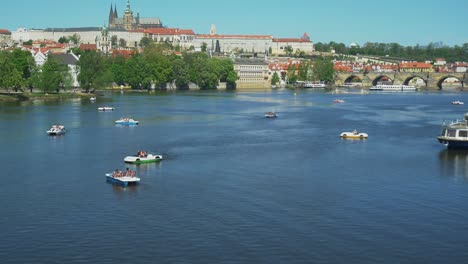 panoramic shot of prague and pedal boats on vltava