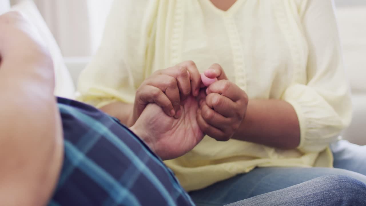 hombre y mujer de edad diversa tomados de la mano en una reunión de grupo de apoyo de amigos de edad avanzada, cámara lenta