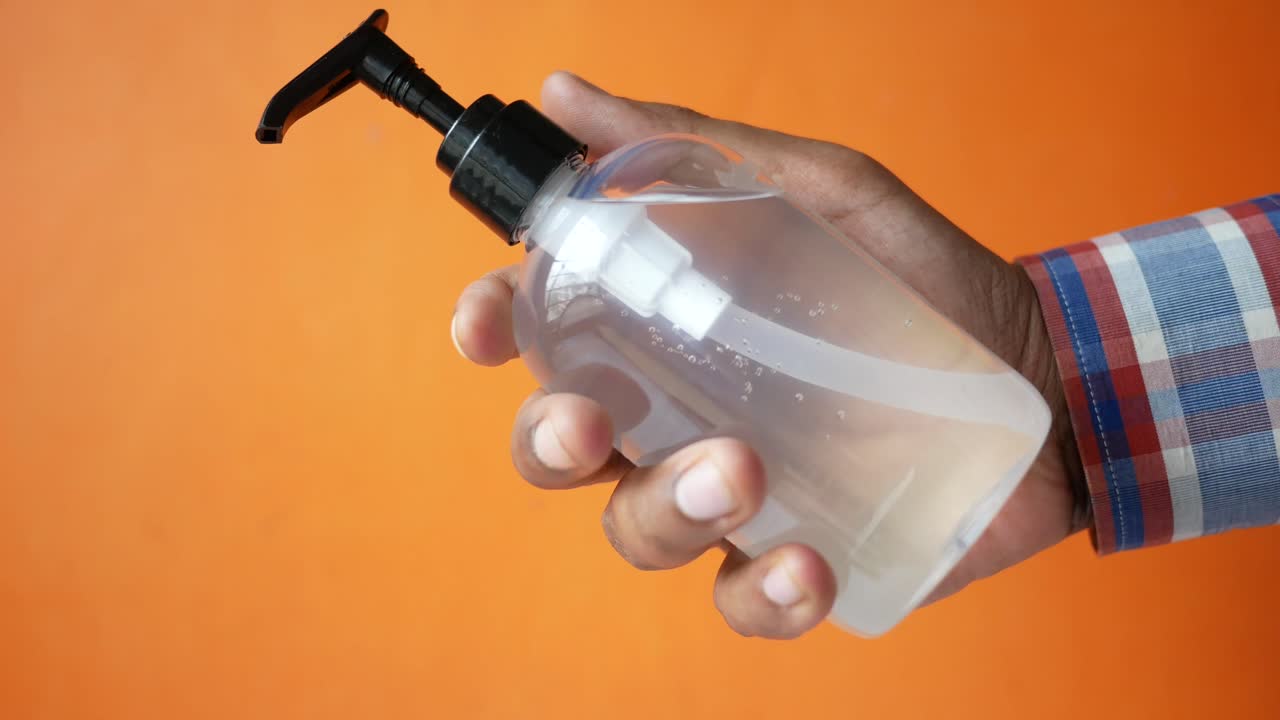 botella de desinfectante de manos en la mano