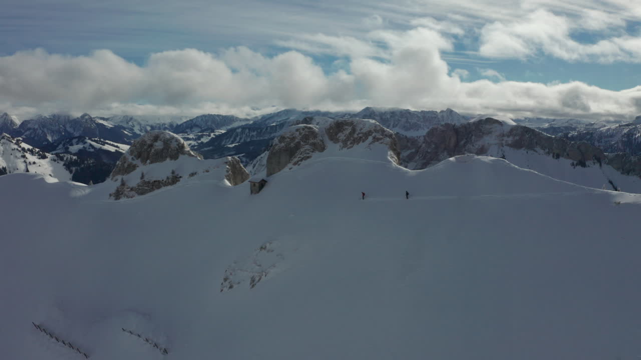 antena de dos esquiadores en una ladera cubierta de nieve con un hermoso paisaje montañoso al fondo