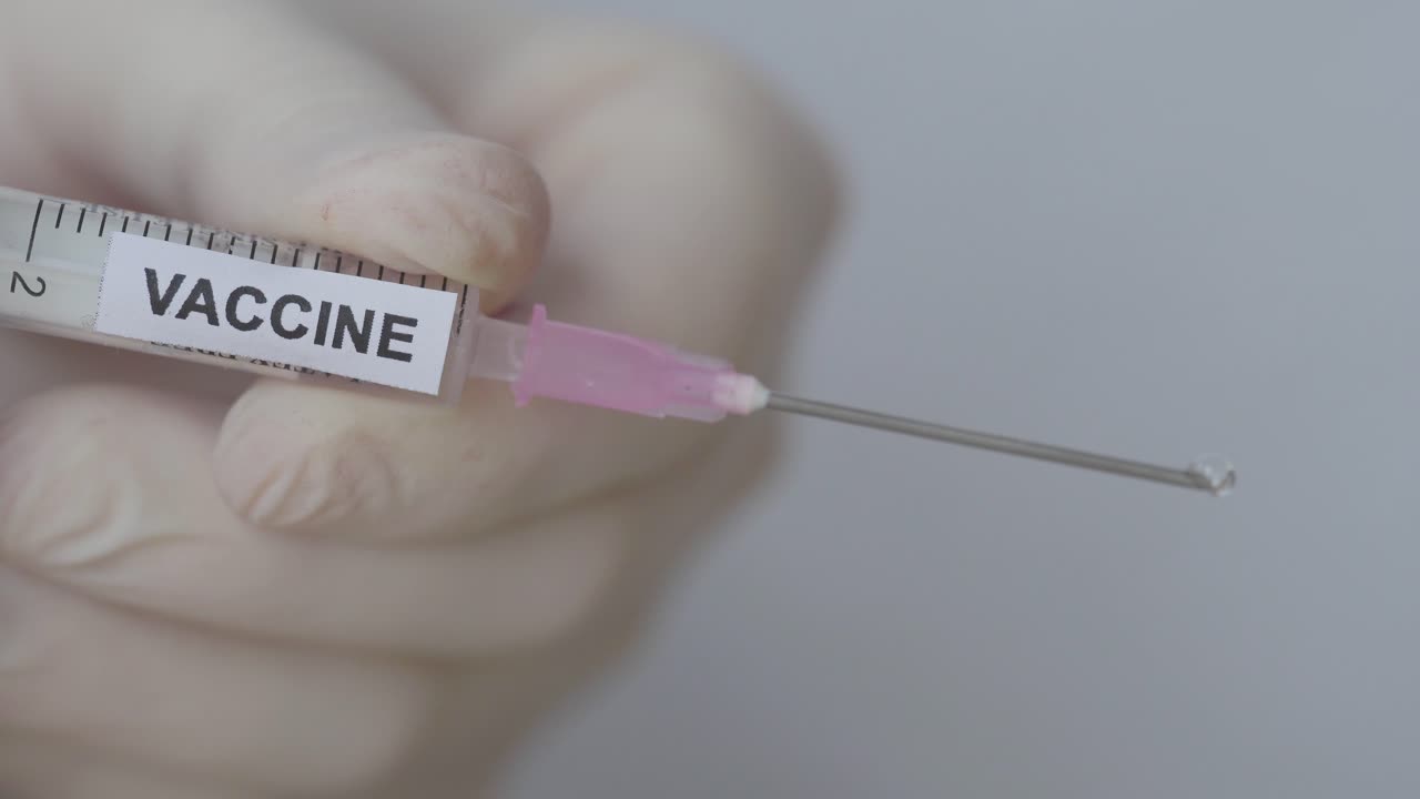 일회용 주사기의 바늘에서 떨어지는 백신액