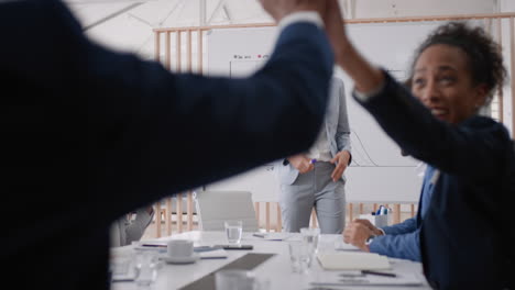 happy-business-people-celebrating-success-in-boardroom-meeting-enjoying-corporate-victory-colleagues-high-five-in-office-presentation