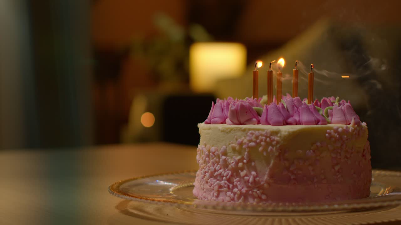 las velas se soplan en el pastel de celebración de la fiesta para el cumpleaños decorado con glaseado en la mesa en casa 2