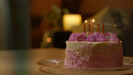 candles being blown out on party celebration cake for birthday decorated with icing on table at home 2