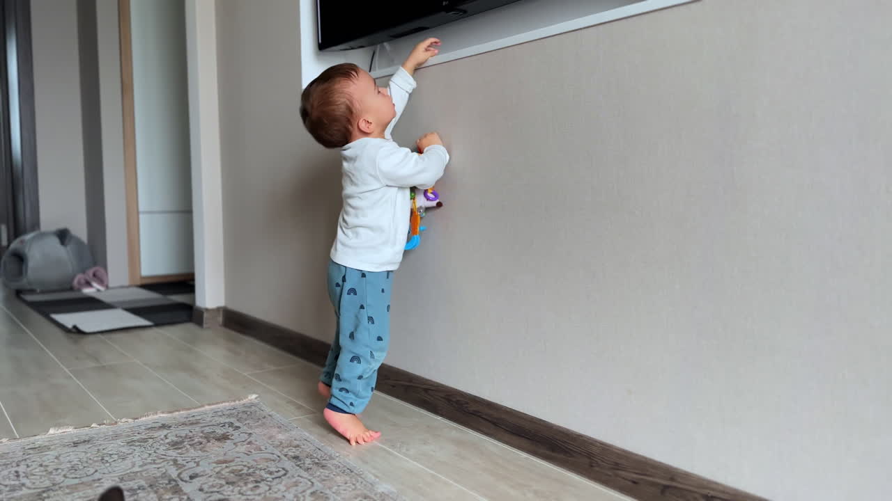 Baby exploring toys near TV